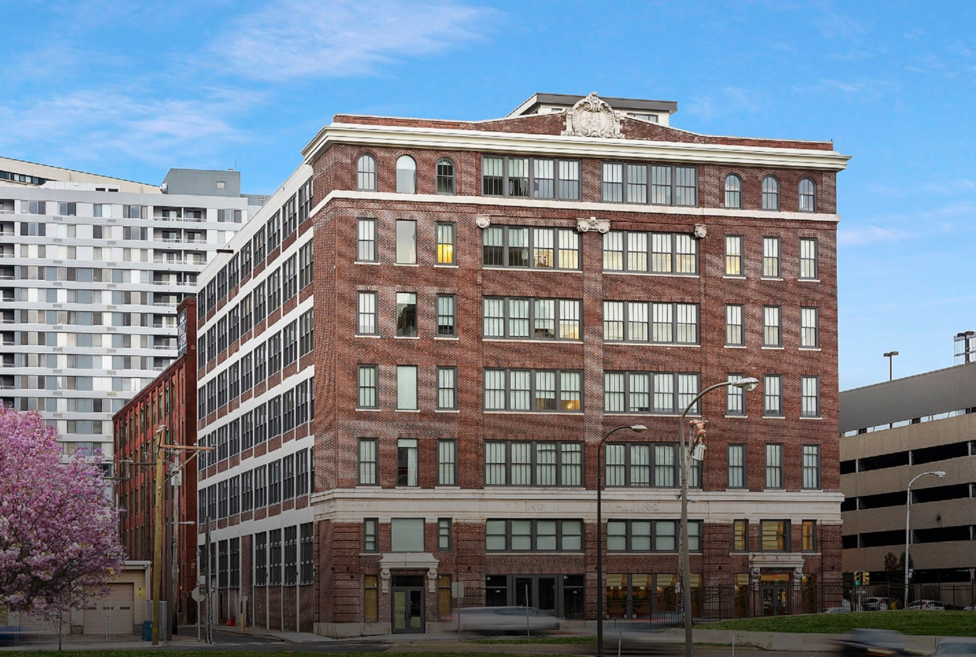 Historic brick building with large windows in an urban setting at sunset.