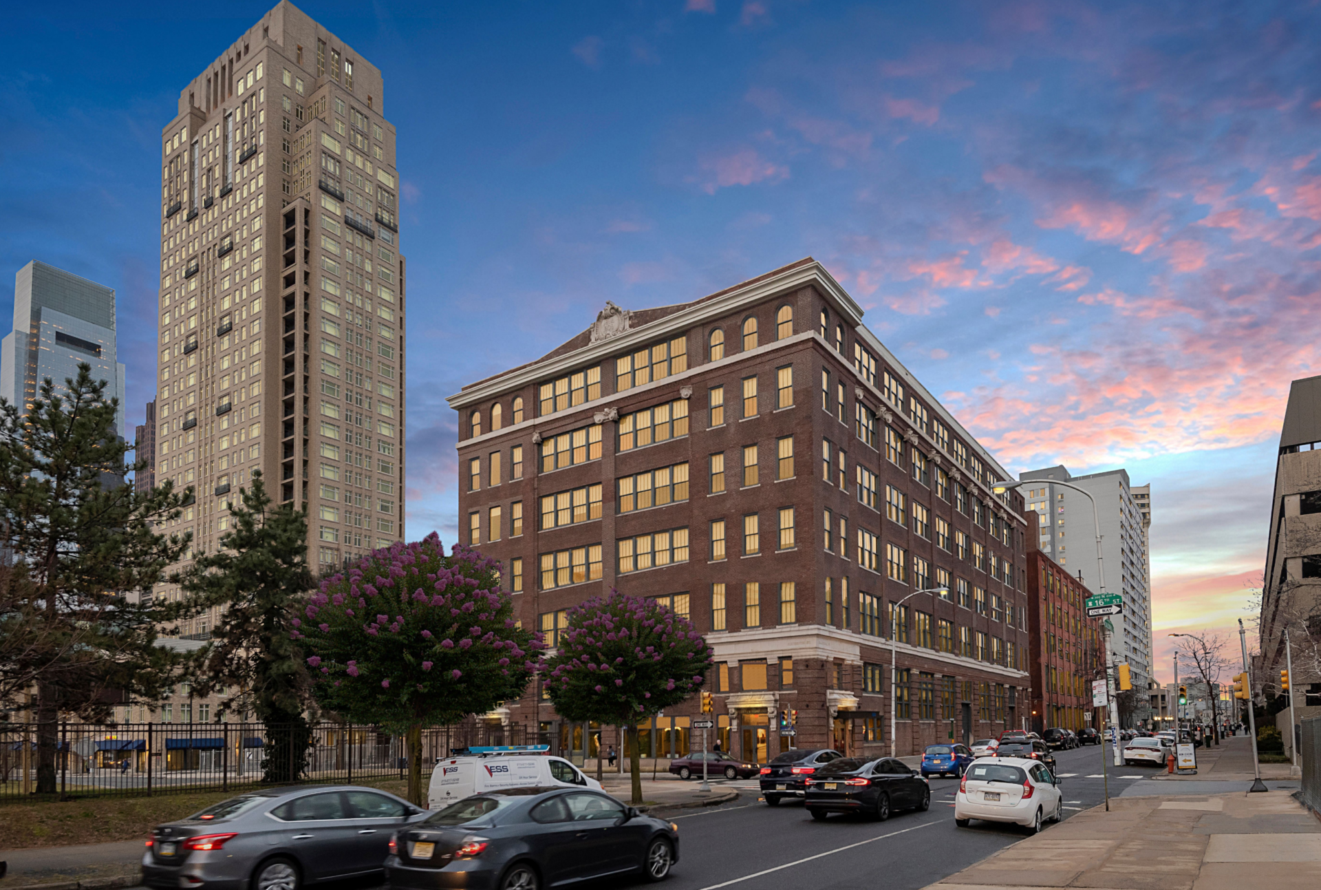 Historic brick building with large windows in an urban setting at sunset.