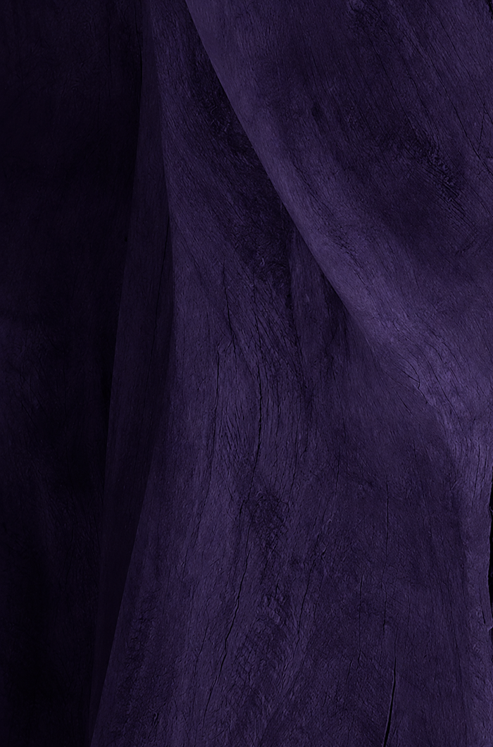 Dark purple textured fabric with soft folds and subtle surface detail.